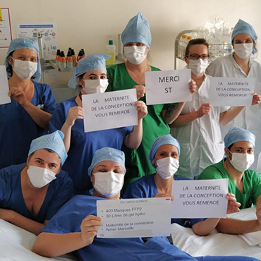 Hospital staff holding signs with thank you messages