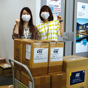 Two woman in front of boxes