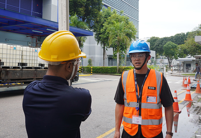 Two workers in safety helmets standing by the street (photo)