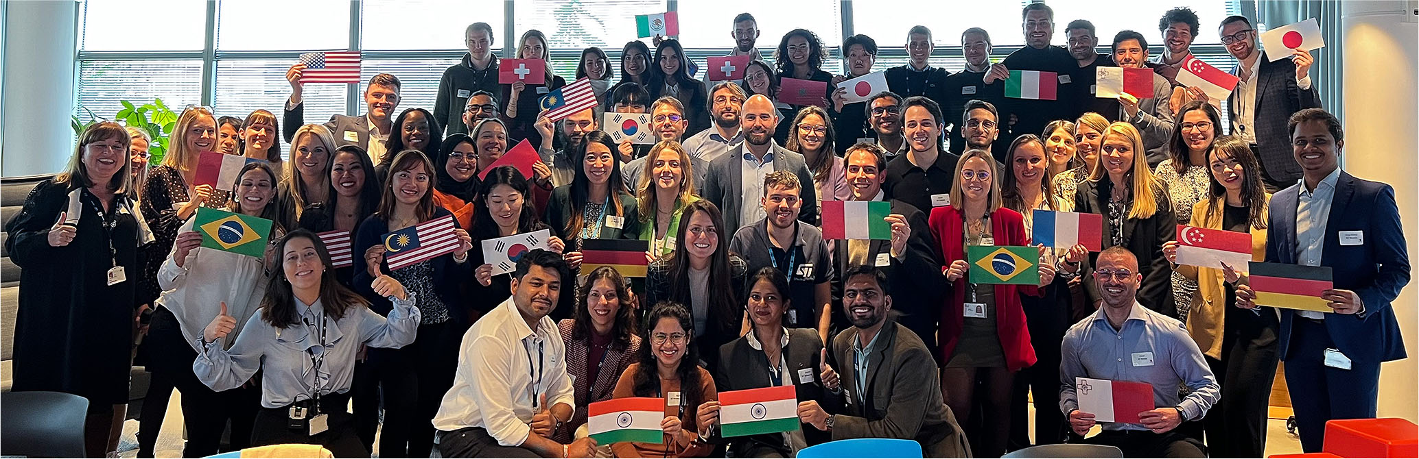 group photo of employees holding flags from different countries (photo)